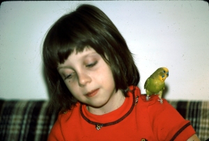 Yvonne at age eight with her pet parakeet
